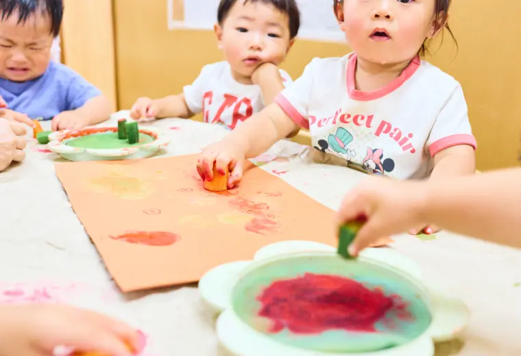 乳児たちが野菜スタンプを楽しんでいる様子