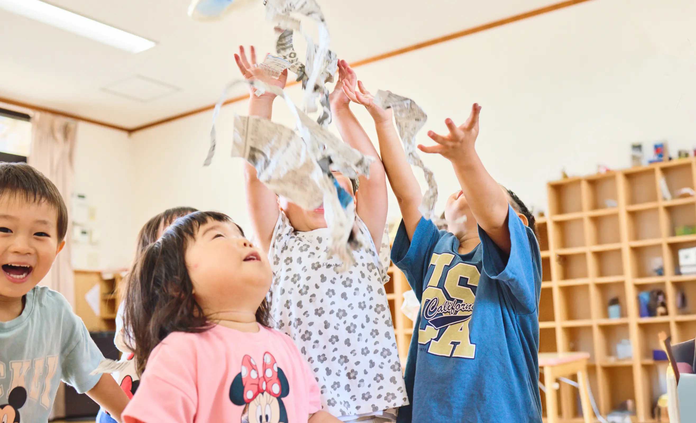 子どもたちが新聞遊びを楽しんでいる様子