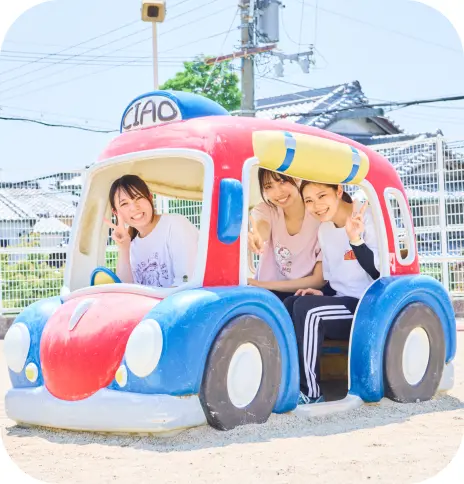 園庭の遊具で楽しむ保育士と子どもたち