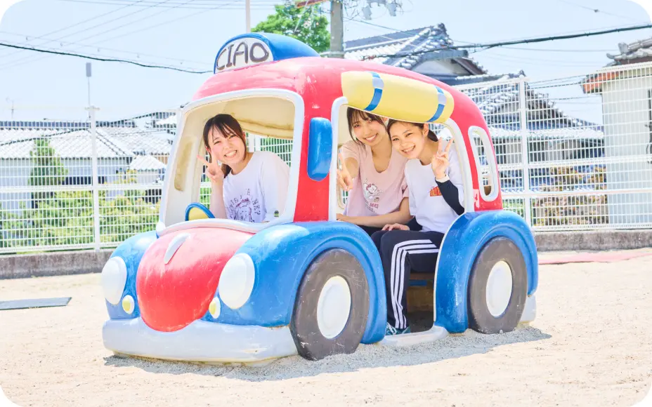 園庭の遊具で楽しむ保育士と子どもたち